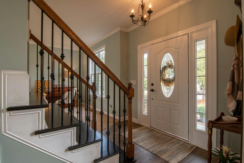 pexels-photo-3288103-3288103 Inviting modern hallway with staircase, chandelier, and natural daylight.